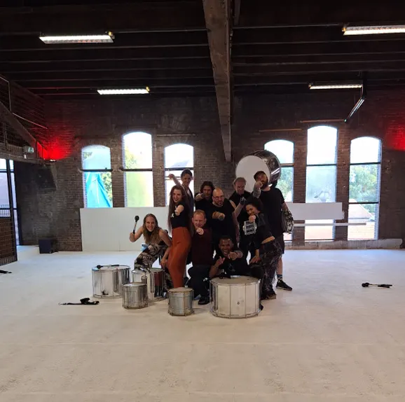 Fenix Drums met surdo’s in een lege fabriekshal met grote ramen